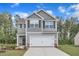Charming two-story home featuring a two-car garage, stone accents, and a well-manicured lawn at 601 Benton Dr, Oxford, NC 27565