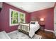 This bedroom features hardwood floors, a brass bed frame, and lots of natural light at 6105 Splitrock Trl, Apex, NC 27539