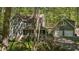 Two-story home with a porch and a detached garage surrounded by lush greenery and blooming flowers at 6105 Splitrock Trl, Apex, NC 27539
