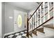 Inviting foyer featuring checkered tile flooring and a staircase with wood accents and unique front door at 6105 Splitrock Trl, Apex, NC 27539