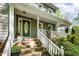 Inviting front porch with brick steps, stylish front door, and lush landscaping at 6105 Splitrock Trl, Apex, NC 27539