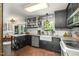 Spacious kitchen with black cabinets, an apron-front sink, and stainless steel appliances at 6105 Splitrock Trl, Apex, NC 27539