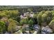 Aerial view of a residential neighborhood with lush green trees and various architectural styles of homes at 703 Midsummer Ln, Apex, NC 27502