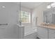 Bright bathroom featuring a separate shower and tub with a large window at 703 Midsummer Ln, Apex, NC 27502