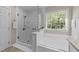 Bright bathroom with a separate shower and tub, complemented by a large window at 703 Midsummer Ln, Apex, NC 27502