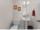 Powder room with pedestal sink, framed art, and neutral decor at 703 Midsummer Ln, Apex, NC 27502