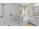 Bright bathroom with a shower and bathtub featuring a large window at 703 Midsummer Ln, Apex, NC 27502