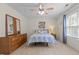 Inviting bedroom features a ceiling fan, bright window with curtains, and a comfortable bed at 703 Midsummer Ln, Apex, NC 27502