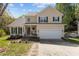 Charming two-story home with green shutters, a two-car garage, and a well-manicured front yard at 703 Midsummer Ln, Apex, NC 27502