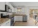 Modern kitchen featuring granite countertops, stainless steel appliances, and white cabinetry at 703 Midsummer Ln, Apex, NC 27502