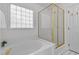 Bathroom featuring a glass-enclosed shower and a luxurious bathtub under a bright window at 720 Raymond Dr, Clayton, NC 27527