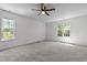 A large bedroom with carpet features a ceiling fan and large windows at 720 Raymond Dr, Clayton, NC 27527