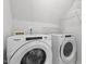Laundry room with modern, white, front-loading washer and dryer, with wire shelving above at 720 Raymond Dr, Clayton, NC 27527