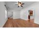 Bright living room featuring hardwood floors, a ceiling fan, and entry to the kitchen and staircase at 720 Raymond Dr, Clayton, NC 27527