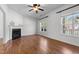 Cozy living room featuring a fireplace, hardwood floors, and bright natural light through large windows at 720 Raymond Dr, Clayton, NC 27527