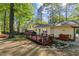 A view of a backyard featuring a deck, a lawn, mature trees, and landscaping at 730 N Harrison Ave, Cary, NC 27513