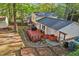 Aerial view of a backyard with a deck, sheds, a hot tub, mature trees, and landscaping at 730 N Harrison Ave, Cary, NC 27513