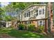 View of the 2-story home's exterior, featuring a brick facade, black shutters and lush landscaping at 730 N Harrison Ave, Cary, NC 27513