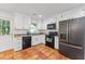 Updated kitchen with granite countertops, terracotta tile flooring, and stainless steel appliances at 730 N Harrison Ave, Cary, NC 27513