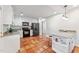 Open kitchen design features terracotta tile flooring, an island, and stainless steel appliances at 730 N Harrison Ave, Cary, NC 27513
