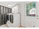 Laundry room featuring modern washer and dryer, complemented by bright white cabinets at 730 N Harrison Ave, Cary, NC 27513