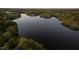 Scenic aerial view of a calm lake surrounded by lush green trees with a hint of sunset at 775 Sagamore Dr, Louisburg, NC 27549