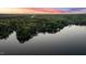 Aerial view of a serene lake surrounded by lush greenery with a vibrant sunset sky at 775 Sagamore Dr, Louisburg, NC 27549