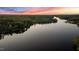 Picturesque aerial view showcasing a tranquil lake bordered by dense forests and a colorful sunset at 775 Sagamore Dr, Louisburg, NC 27549