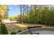 Scenic backyard view with a stone patio, leading to a serene lake with a private dock at 775 Sagamore Dr, Louisburg, NC 27549