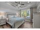 Bedroom with tray ceiling, ceiling fan, lake views from window and wood floors at 775 Sagamore Dr, Louisburg, NC 27549