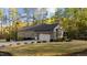 Spacious garage with white doors, set in a lush green lawn and landscaped beds at 775 Sagamore Dr, Louisburg, NC 27549