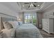This gorgeous bedroom features a beautiful lake view, tray ceilings, and elegant decor at 775 Sagamore Dr, Louisburg, NC 27549
