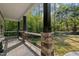 Inviting porch features stone columns, white railing, and wood ceiling with a beautiful view at 775 Sagamore Dr, Louisburg, NC 27549