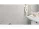 A pedestal sink in a well-lit bathroom has a decorative mirror and fresh white towels at 7822 Allscott Way, Raleigh, NC 27612