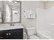 Well-lit bathroom with vanity, toilet, tub, and tiled wall at 7822 Allscott Way, Raleigh, NC 27612
