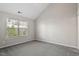 A bright, empty bedroom with neutral walls, carpet flooring and a large window at 7822 Allscott Way, Raleigh, NC 27612