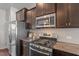A kitchen features stainless steel appliances, dark cabinets and granite countertops, ready for cooking at 7822 Allscott Way, Raleigh, NC 27612