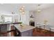 Open concept kitchen and dinette area featuring granite countertops, dark cabinetry and modern lighting at 7822 Allscott Way, Raleigh, NC 27612