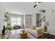 Bright living room with a ceiling fan, large windows and a comfortable neutral colored couch at 7822 Allscott Way, Raleigh, NC 27612