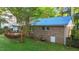 The grassy, partially fenced yard has a wooden deck and patio, a brick house, and mature shade trees at 801 Silver Leaf Pl, Raleigh, NC 27609