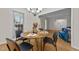 Open dining room with modern chandelier and hardwood floors at 801 Silver Leaf Pl, Raleigh, NC 27609