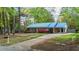 Beautiful brick home with blue metal roof, shutters, and lush landscaping at 801 Silver Leaf Pl, Raleigh, NC 27609
