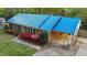 View of home with blue metal roof, colorful landscaping, a covered carport, and a brick facade at 801 Silver Leaf Pl, Raleigh, NC 27609