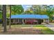 Beautiful brick home with a blue metal roof, bright shutters and colorful blooming azaleas at 801 Silver Leaf Pl, Raleigh, NC 27609