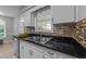 Updated kitchen featuring stainless steel sink, white cabinets, and granite countertops at 801 Silver Leaf Pl, Raleigh, NC 27609