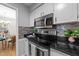 Close up of kitchen featuring stainless appliances, black counters, and tile backsplash at 801 Silver Leaf Pl, Raleigh, NC 27609