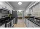 Galley kitchen with stainless steel appliances, white cabinets, and a tile backsplash at 801 Silver Leaf Pl, Raleigh, NC 27609
