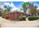 The backyard with brick and greenery features a classic brick house with a spacious driveway and landscape at 806 S Second St, Smithfield, NC 27577