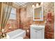 Bathroom with floral wallpaper, vanity, tub and window at 806 S Second St, Smithfield, NC 27577