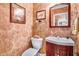 Elegant powder room featuring decorative wallpaper and a cherry vanity at 806 S Second St, Smithfield, NC 27577